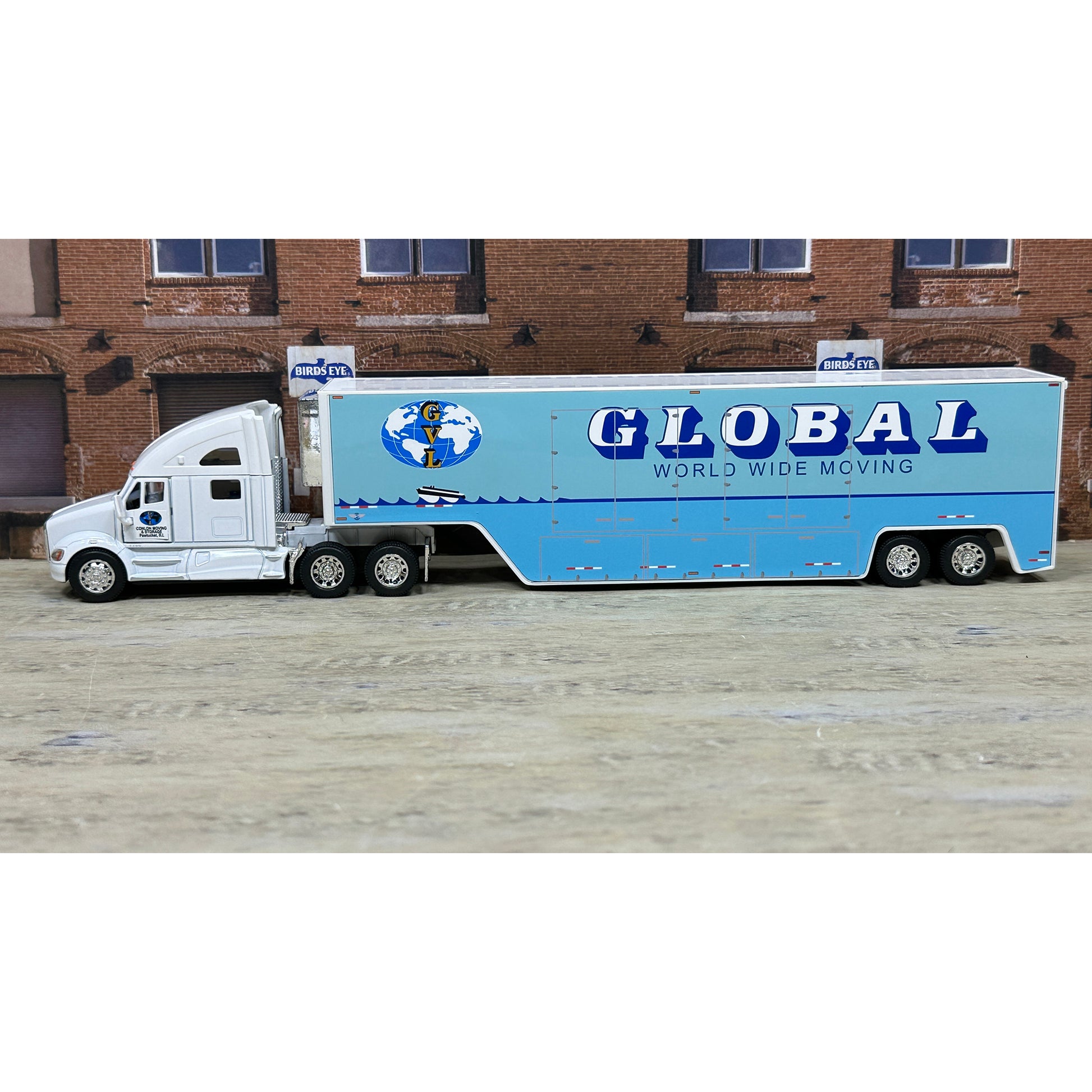 Model truck with 'Global World Wide Moving' branding in front of a brick building.