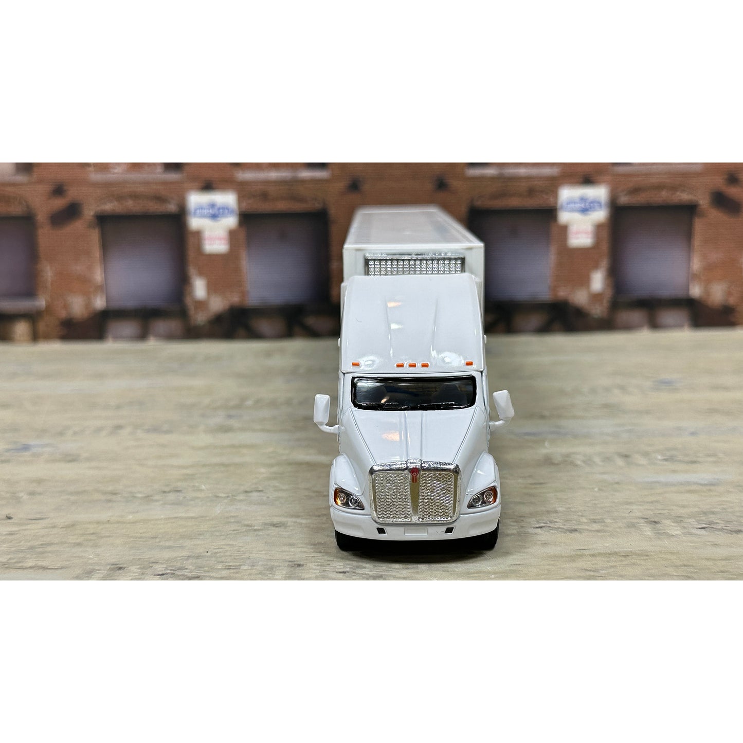 Model of a white truck with a trailer on a wooden surface