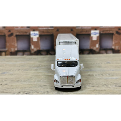 Model of a white truck with a trailer on a wooden surface
