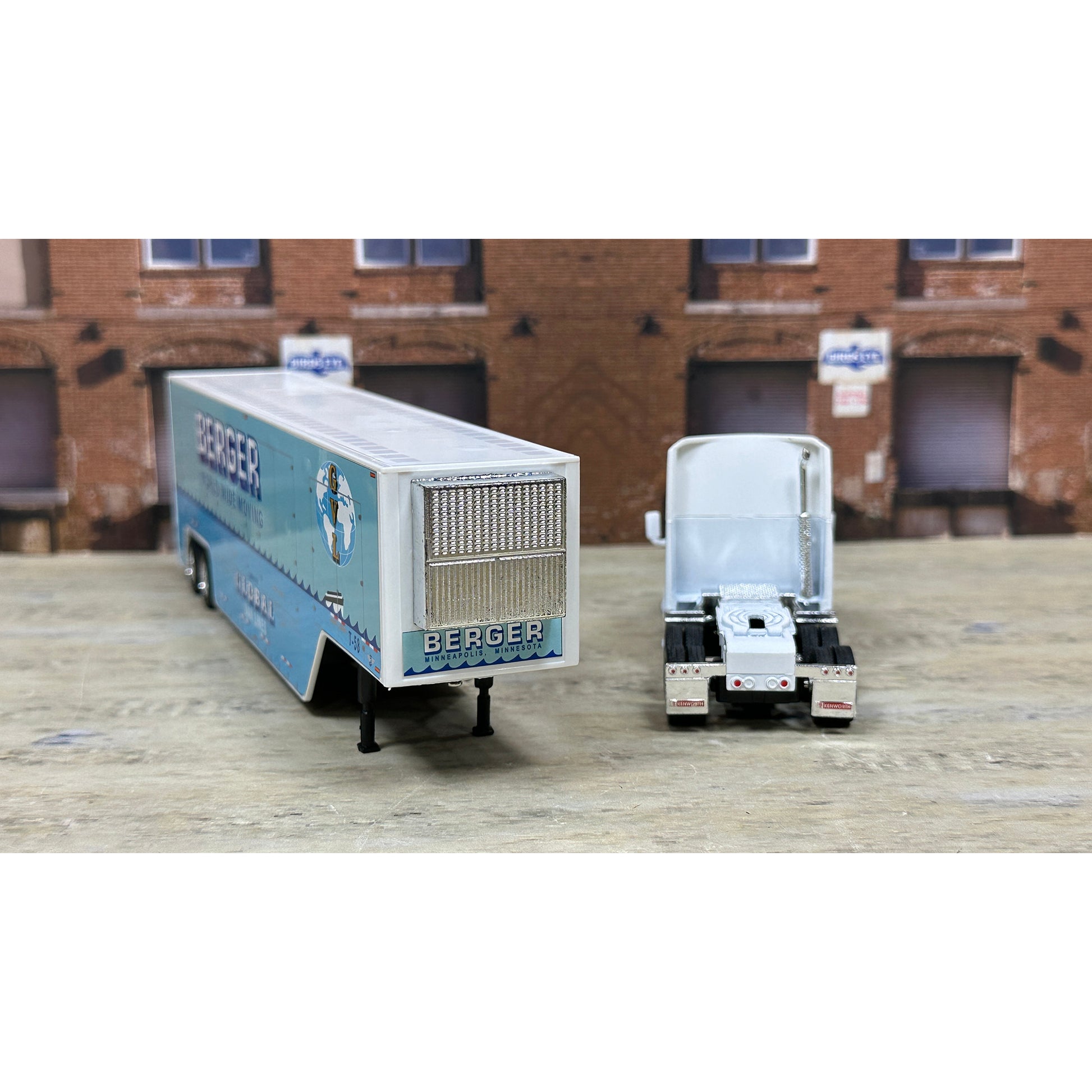 Model trucks with 'Berger' branding on a wooden surface in front of a brick building.